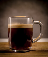Freshly brewed cup of coffee on a wooden table - studio photography