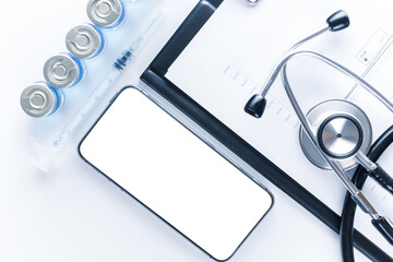 Medical equipment. Doctor stethoscope, healthcare charts, syringe with needle and black smartphone with blank screen on hospital equipment background. For design application, website project.