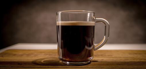 Freshly brewed cup of coffee on a wooden table - studio photography