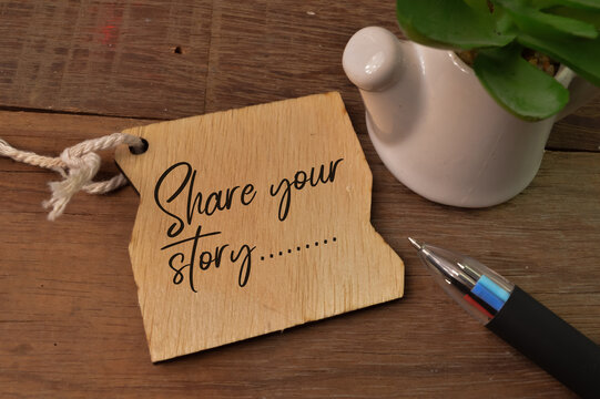 Wooden board written with SHARE YOUR STORY.