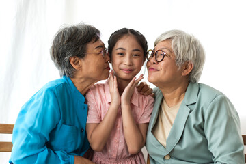 Portrait of happy asian grandmother and little asian cute girl enjoy relax in home.Young girl with their laughing grandparents smiling together.Family and togetherness