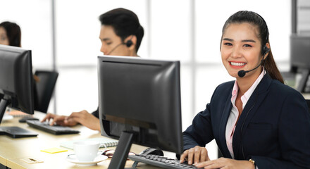 Group of happy asian smiling call center business operator customer help support team phone services agen working and talking with headset on desktop computer at call center office