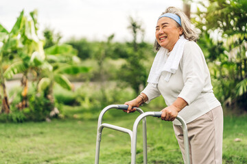Portrait of happy senior adult elderly asian woman smiling and feeling breathe fresh air and exercise on sunny morning in the park.Retirement and healthcare concept
