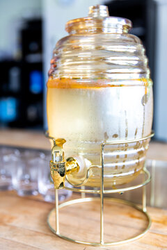 r&eacute;cipient d'eau fraiche d&eacute;pos&eacute; sur un comptoir avec des verres laiss&eacute; pour que les invit&eacute;s se servent