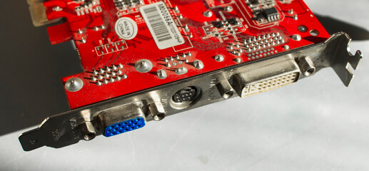 Details of the old computer graphics card on a gray background. Old red graphics card. GPU