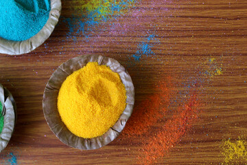 Fototapeta na wymiar Indian Holi traditional colors in disposal organic bowl, different organic Gulal color on the occasion of Holi festival, Abstract background, selective focus with blur. 