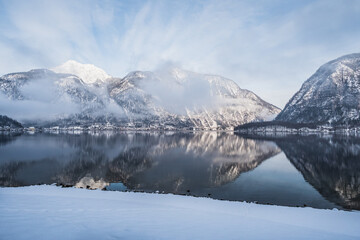 Fototapeta na wymiar Lake Hallstatt or Hallstatter See in Winter in the Salzkammergut, Upper Austria , with Snow Covered Mountains on a Cold January Morning