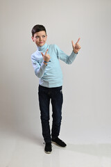 Vertical photo in full growth of a caucasian teenager guy on a white background standing