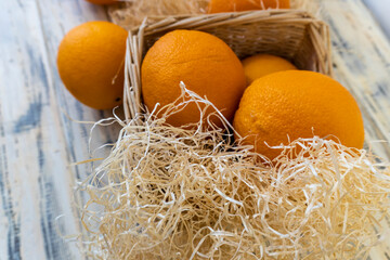 Still life with oranges and basket on old bright wooden background