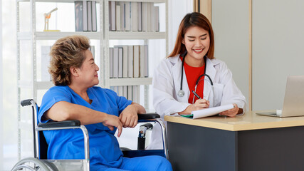 Obraz premium Asian woman doctor writing note and near with elderly female as sitting on wheelchair both of them are smiling look to happy and comfortable at hospital in the morning
