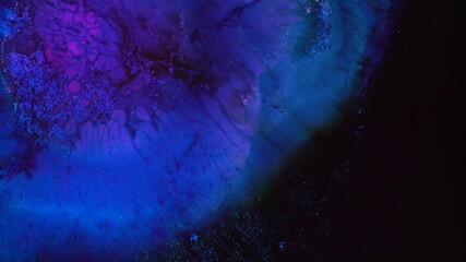 Neon blue purple dark colors ink and shiny particles macro. Liquid abstractions. Abstract painting texture. Colorful amazing organic background. Fluid art. The universe, the cosmos