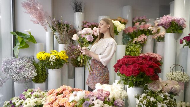 Inspired woman in a fresh flower warehouse. Service for the delivery of fresh flowers.