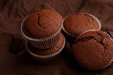 Chocolate cupcakes with cane sugar and a crispy top. Chocolate muffins on linen fabric.