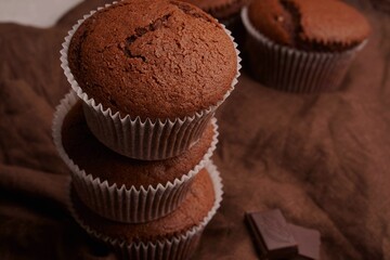Chocolate cupcakes with cane sugar and a crispy top. Chocolate muffins on linen fabric.