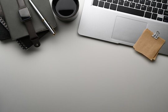 Creative designer workplace with laptop computer, smart watch, notebook and copy space on white table.