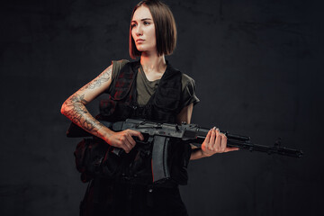 Seductive military girl holding rifle in dark background