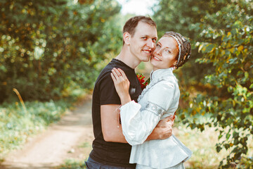 Fototapeta premium a guy and a girl are standing in an embrace on a field of grass