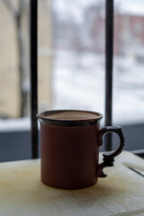 ceramic cup with a drink on a quiet near the window
