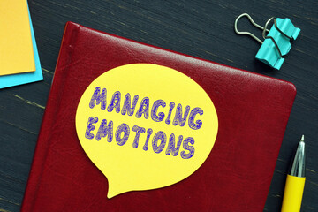 Business concept meaning MANAGING EMOTIONS with inscription on the page.