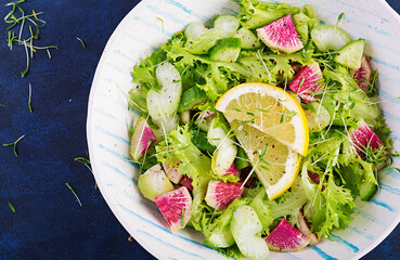 Salad from watermelon radish, cucumber, celery and lettuce leaves. Vegan food. Dietary menu. Top view, overhead, copy space