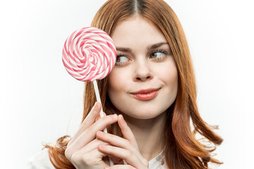 cheerful pretty woman with a round lollipop near face emotions joy