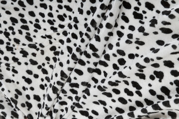 Colored black textile satin fabric folded in folds and waves with highlights and texture