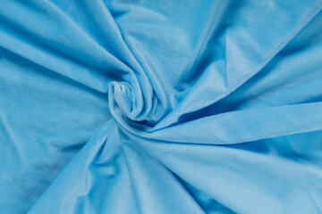 Colored blue textile satin fabric folded in folds and waves with highlights and texture