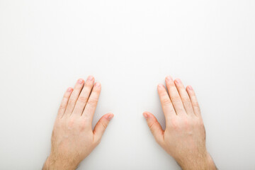 Young adult man hands on light gray table background. Closeup. Point of view shot. Top down view.
