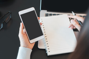 Asian women freelancer working with computer, mobile phone and notebook on table while sitting in coffee shop. Business, lifestyle and technology concept. Top view