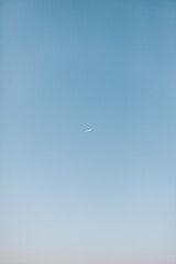Plane taking off on blue sky in the distance.