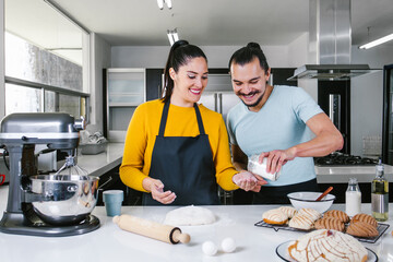latin couple bakers preparing dough for baking mexican bread called Conchas in kitchen in Mexico city