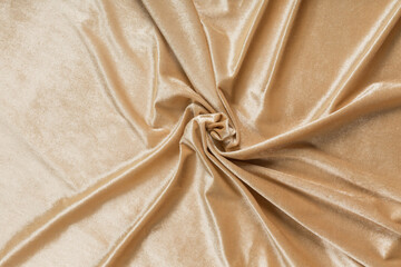 Colored brown textile satin fabric folded in folds and waves with highlights and texture