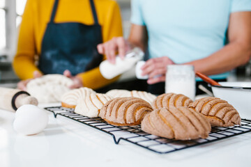 hands of mexican bakers preparing dough for Conchas mexican traditional bread in kitchen in Mexico city