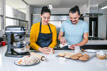 mexican couple bakers preparing dough for baking bread called Conchas in kitchen in Mexico city