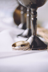 Gold ring on a white background with iron cups. Wedding Ring