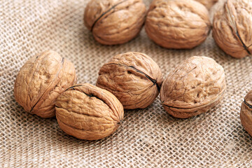 Close-up walnuts lie on a burlap.