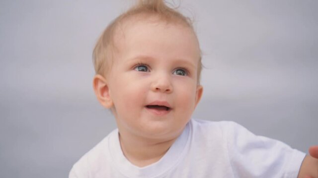 Beautiful smiling cute baby. Portrait of a happy child on a blue background. Funny happy child smiling at the camera.