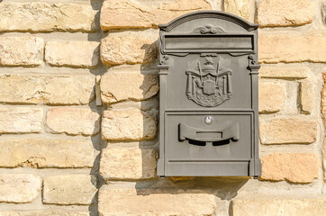 Hanging ornamental mailbox on the facade of the house