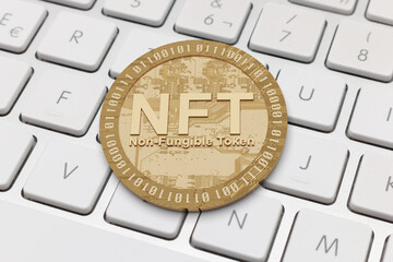 Golden NFT on white keyboard. Non fungible token