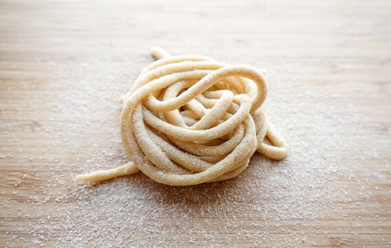 Fresh Pici Pasta nest on a wooden board