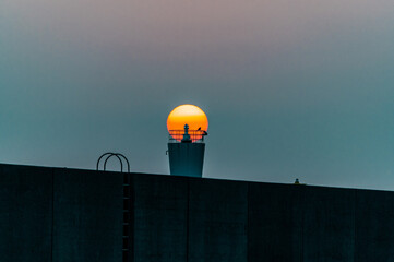 灯台越しに登る朝陽