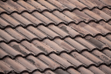 ribbed tiled roof old and weathered closeup background dark brown