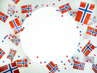 Obraz premium Norwegian independence day, Constitution day, may 17. holiday of freedom, victory and memory. concept of patriotism and faith. paper confetti and mini flags on white foggy background