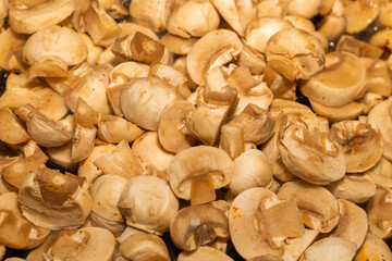 fresh champignons mini halves in a pan closeup background