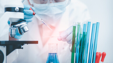 biochemical research scientist working with microscope for coronavirus, laboratory glassware...