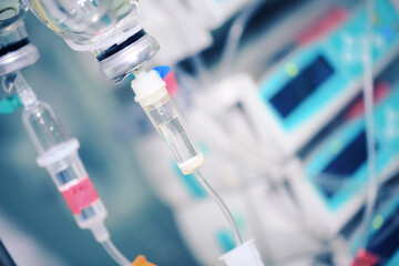 Intravenous drip bottles on the background of hospital equipment