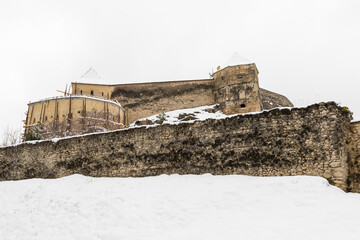 Naklejka premium An Old Medieval Fortification Surrounded by a High Wall and Covered by Snow