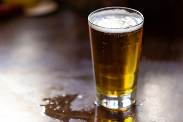 beer in a glass stands on a bar counter with copy space