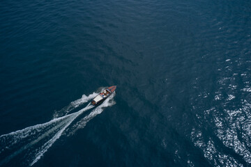 Speed boat at sea, view from above. Vintage wooden boat in sea. Boat drone photo.