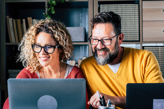 Happy Adult Couple Work At Home Together With Video Conference Call From Room Office In Smart Working And Modern Online Digital Job - Young People Enjoy Internet Connection And Laptop Computer